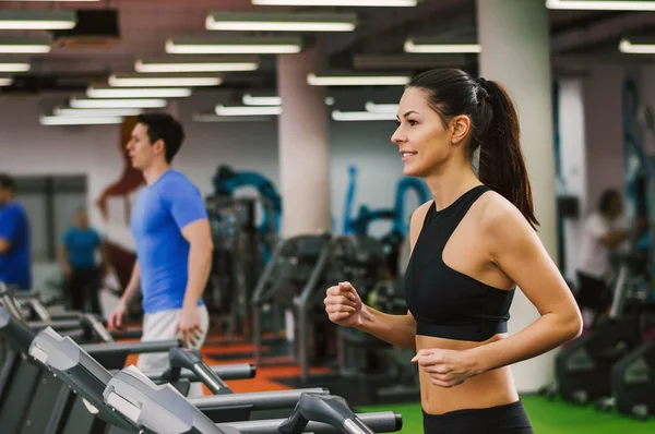 Koşu bandı üzerinde yürüyen insanlar  