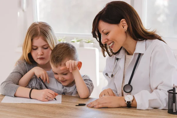 Läkare och barn som leker vid kliniken — Stockfoto