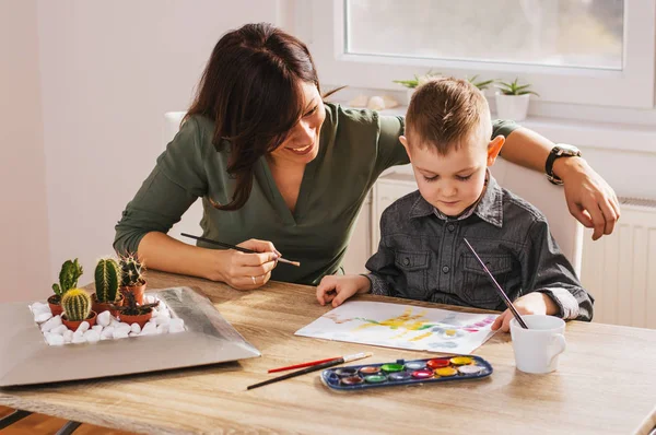 Mother painting with son