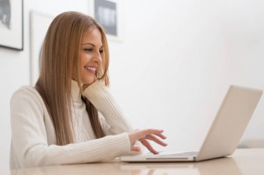 bir dizüstü bilgisayar ile çalışan kadın. 