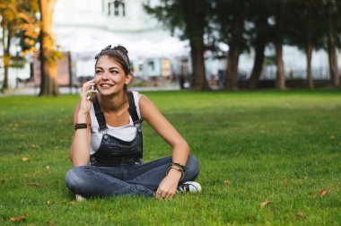 Bir telefon kullanan genç gülümseyen kız