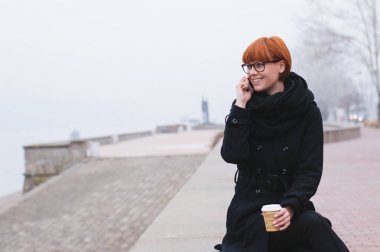 Kadın cep telefonuyla konuşuyor.