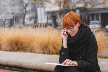 Kızıl saçlı kadın w notlar alır