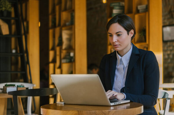 Beautiful young woman looking at laptop