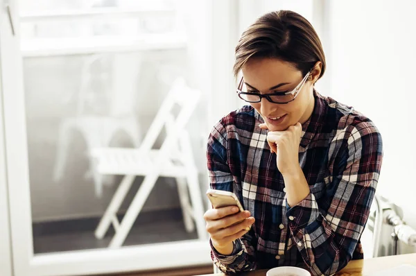 Girl using her smartphone at home — Stock Photo, Image