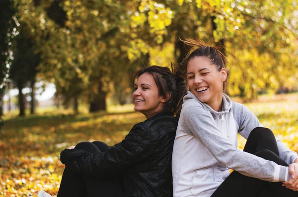 Jonge vrouwen zitten op gras — Stockfoto