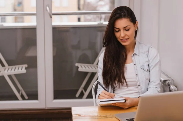 Belle jeune étudiante écrivant ses devoirs — Photo