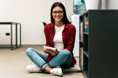 Genç kadın kitap okuyor.