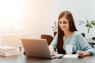 Dizüstü bilgisayarda yazan genç kadın..