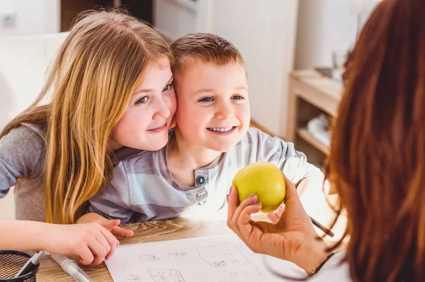 Vrouwelijke arts een appel te geven aan kinderen — Stockfoto