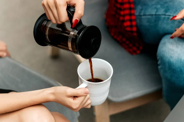 Женщина наливает кофе в чашку. — стоковое фото