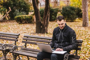  parkta dizüstü bilgisayarda çalışan adam.