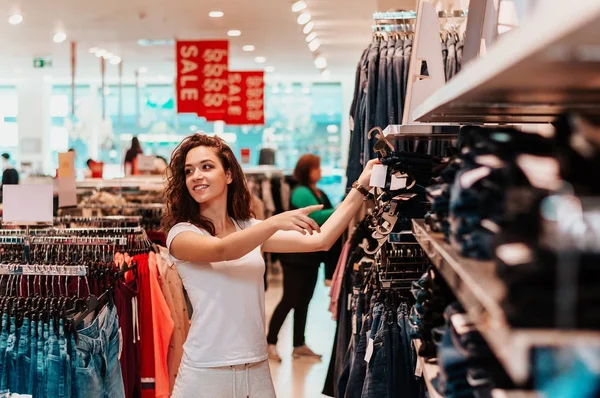 girl choosing jeans in store.