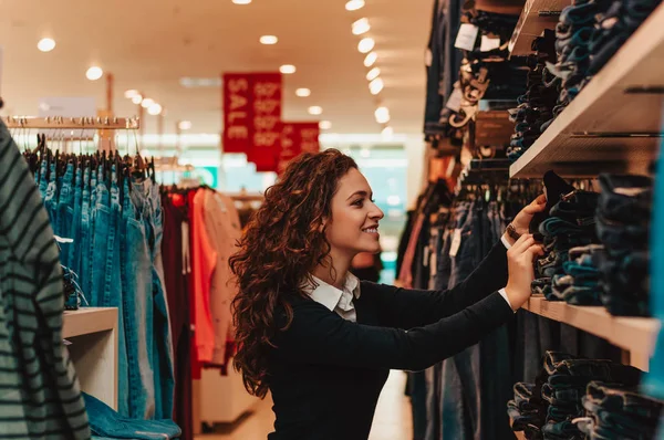 Mujer elegir un jeans para comprar . — Foto de Stock