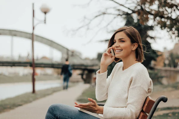 Joven hermosa mujer sentada en un banco — Foto de Stock