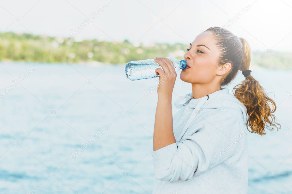 girl in sport clothes drinking water 