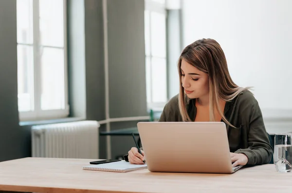 Chica en la biblioteca de escritura en cuaderno . — Foto de Stock