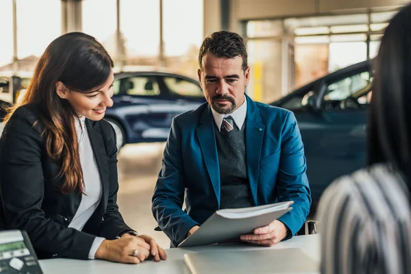 Autohändler zeigt Kunden Vertrag. — Stockfoto