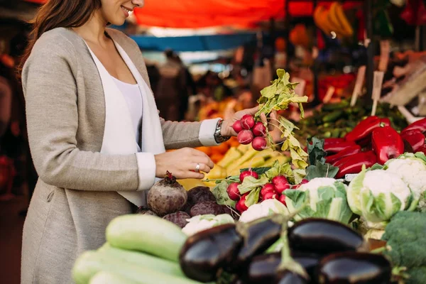 Молодая женщина выбирает овощи — стоковое фото