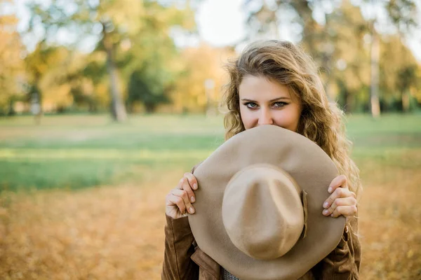 Mujer sosteniendo sombrero en otoño parque . —  Fotos de Stock