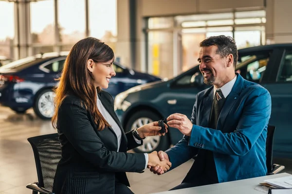 Dealer giving key to new owner — Stock Photo, Image