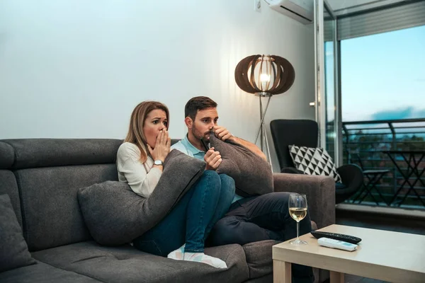 Shocked couple looking at tv.