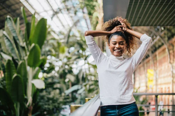 Mujer sosteniendo su pelo afro muy rizado . — Foto de Stock