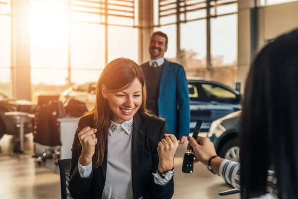 Frau erhält Schlüssel für ein neues Auto — Stockfoto