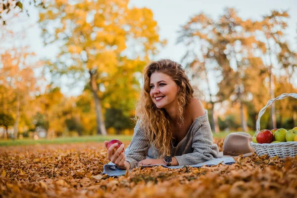 Young woman laying in the autumn park. — Stock Photo, Image