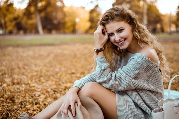 Woman sitting on autumn leaves. — Stock Photo, Image