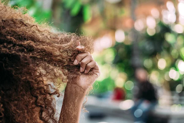 Mano de mujer tocando su pelo rizado . — Foto de Stock