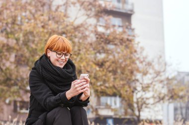 cep telefonu kullaranarak Kızıl saçlı kadın 