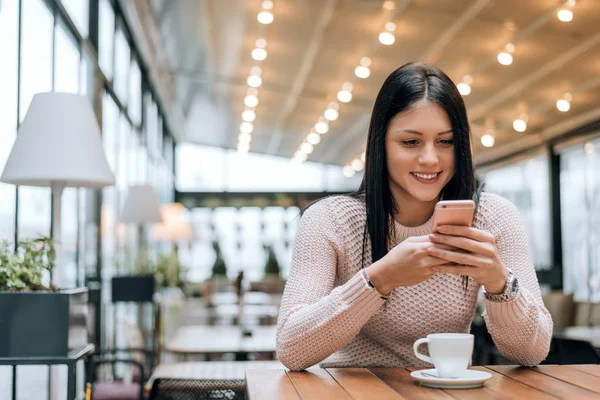Женщина в кафе читает текстовое сообщение — стоковое фото
