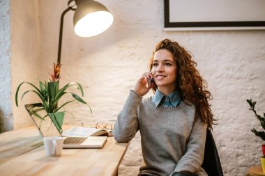 Genç bayan telefonda konuşuyor.