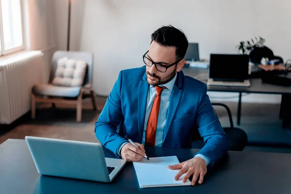 Dizüstü bilgisayar kullanan iş adamı.