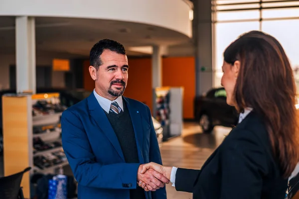 Zakenman schudden handen met autohandelaar. — Stockfoto