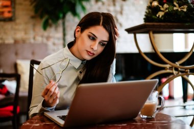 kafede dizüstü kullanan kadın.
