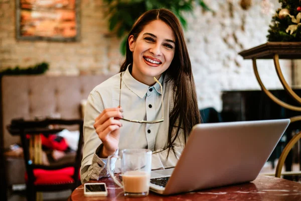 Gadis memegang kacamata sambil duduk di kafe — Stok Foto