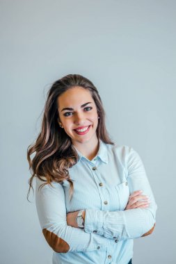 Gri arka plan üzerinde duran gülümseyen kadın portresi