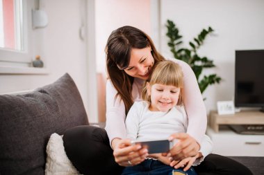 Anne selfie smartphone kullanarak küçük kızıyla yaptırıyor