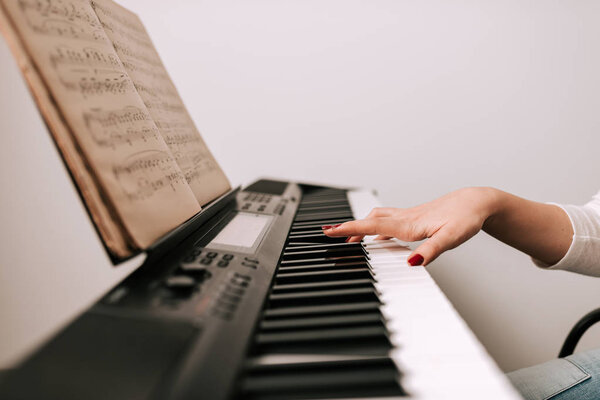 Женщина играет на фортепиано из классической ноты
