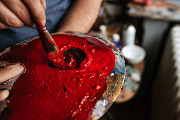 stock image Close up of artist hand taking red color from palette