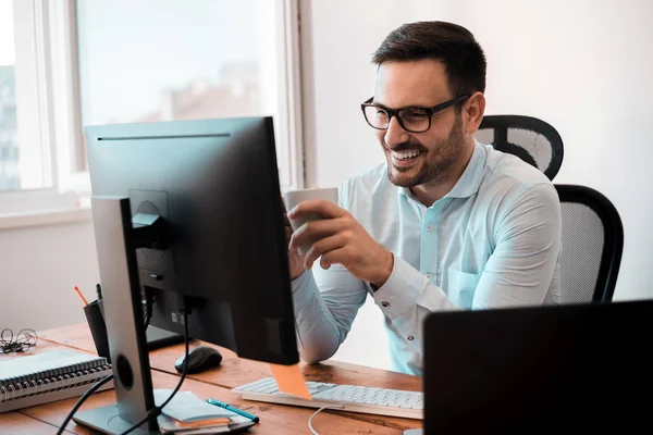 Hombre Negocios Sonriente Sosteniendo Taza Café Mientras Trabaja Escritorio Oficina —  Fotos de Stock