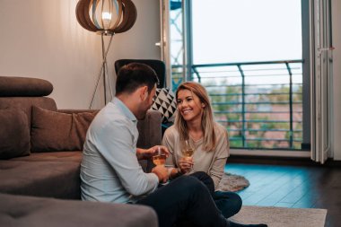 Çift evde şarap içme keyfini çıkarın. Katta oturan.