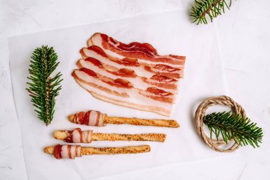 Simit beyaz zemin üzerine sarılı dilimlenmiş domuz pastırması Üstten Görünüm.