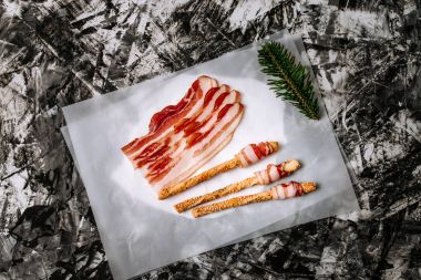 Üstten Görünüm dilim pastırma ve tuzlu kraker, kagit üzerinde sopa. Alüminyum folyo gibi arka plan.