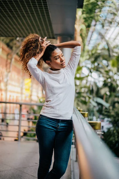 Gorgeous Girl Tying Her Curly Hair Outdoors — Stock Photo, Image