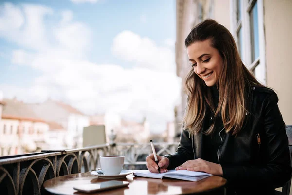 Mädchen Schreibt Notizbuch Während Sie Auf Dem Balkon Der Altstadt — Stockfoto