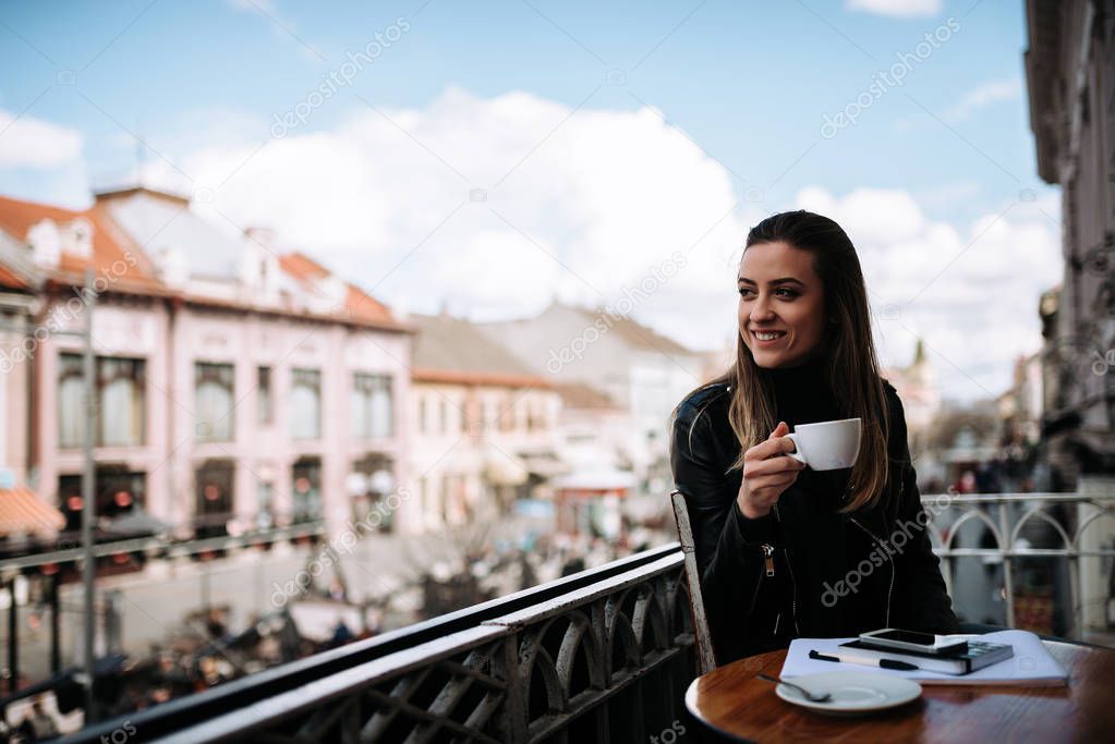 Woman journalist taking a break. Drinking cp of coffee on the balcony.