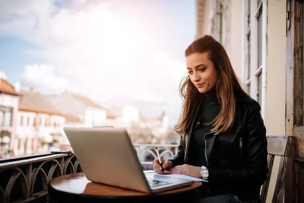 Junge Geschäftsfrau Schreibt Notizbuch Während Sie Vor Laptop Sitzt — Stockfoto